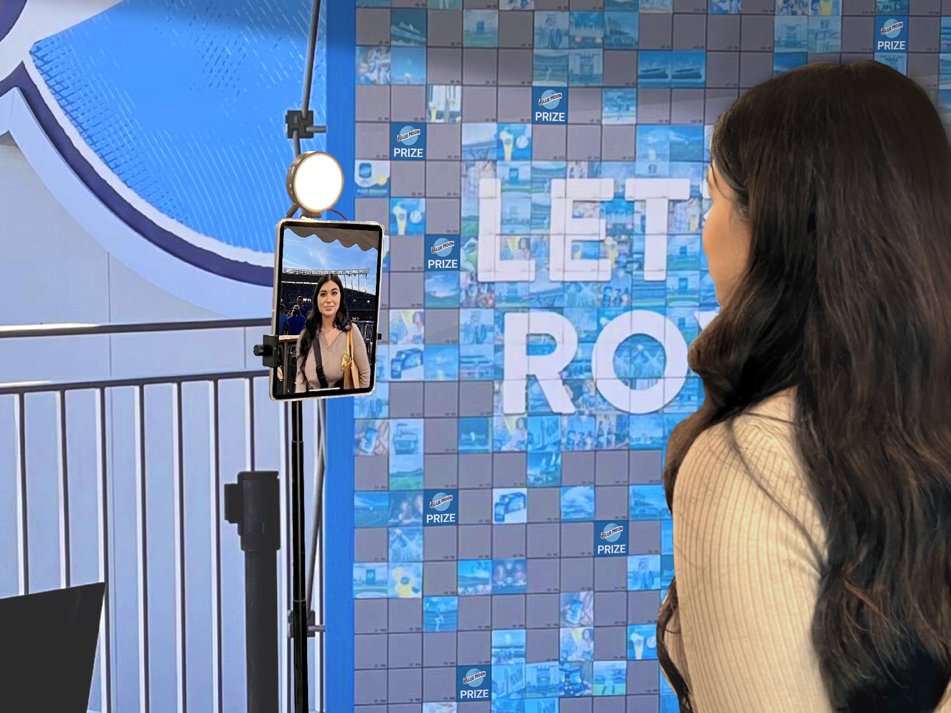 Woman posing for a selfie to stick onto the photo mosaic wall