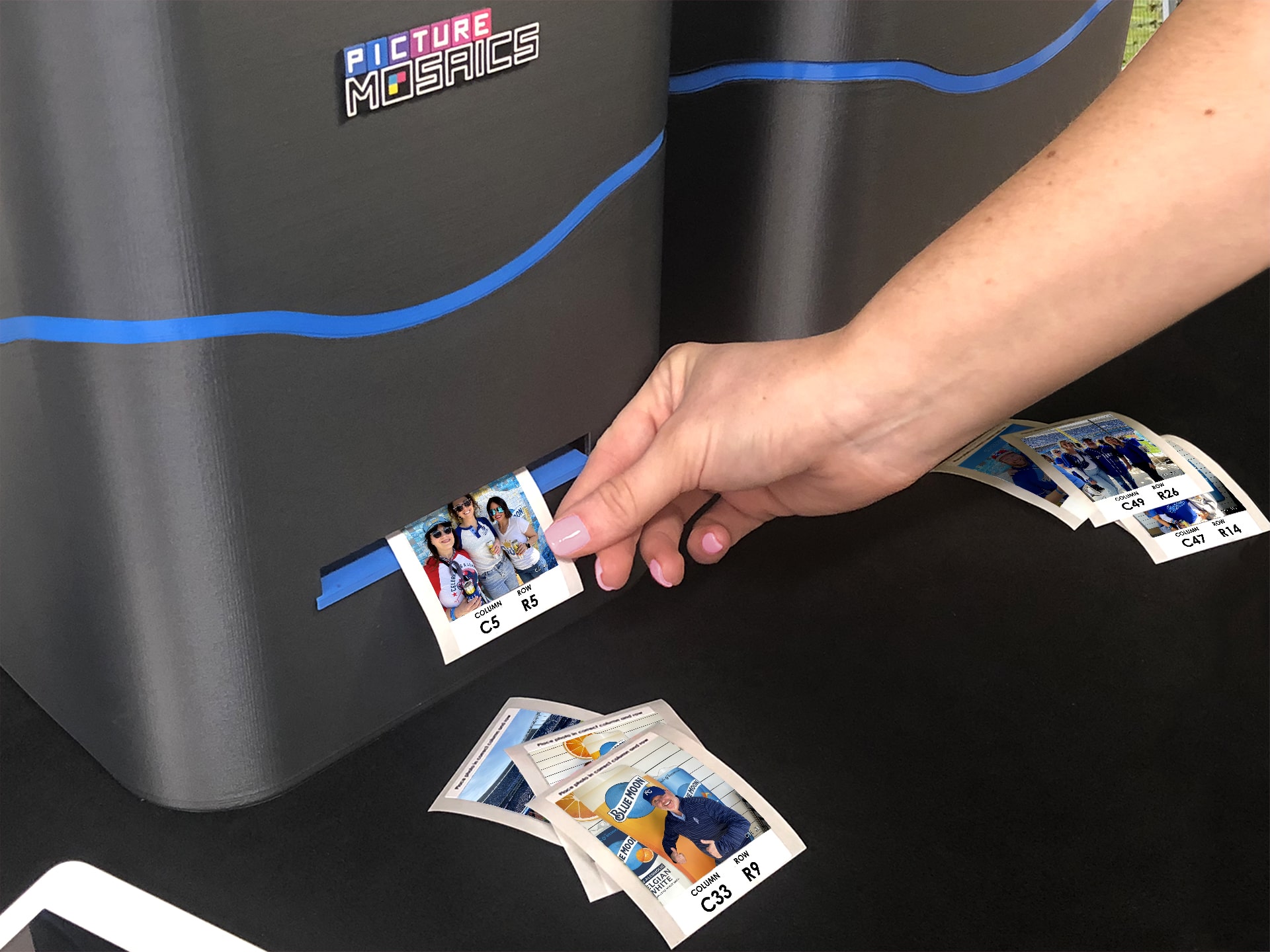 Guest taking a group photo from the printer to stick onto the photo mosaic wall