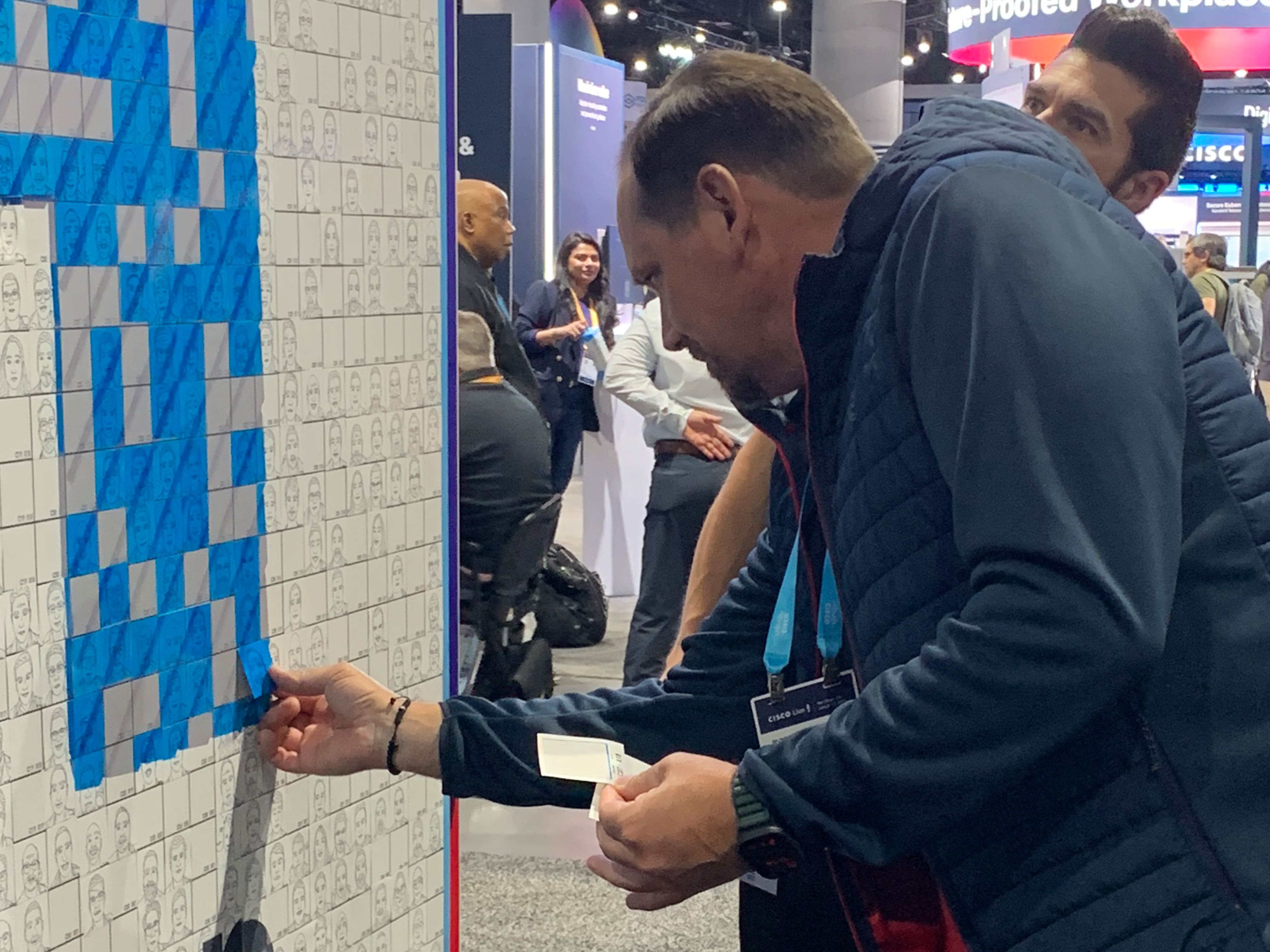 A guest adding their sketch tile to the SketchBot Mosaic