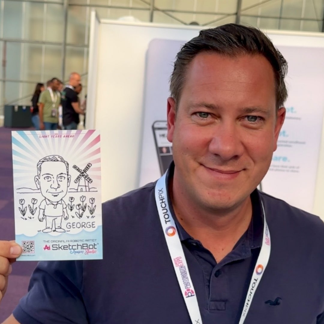 A guest holding up a sketch of themself standing in front of a windmill