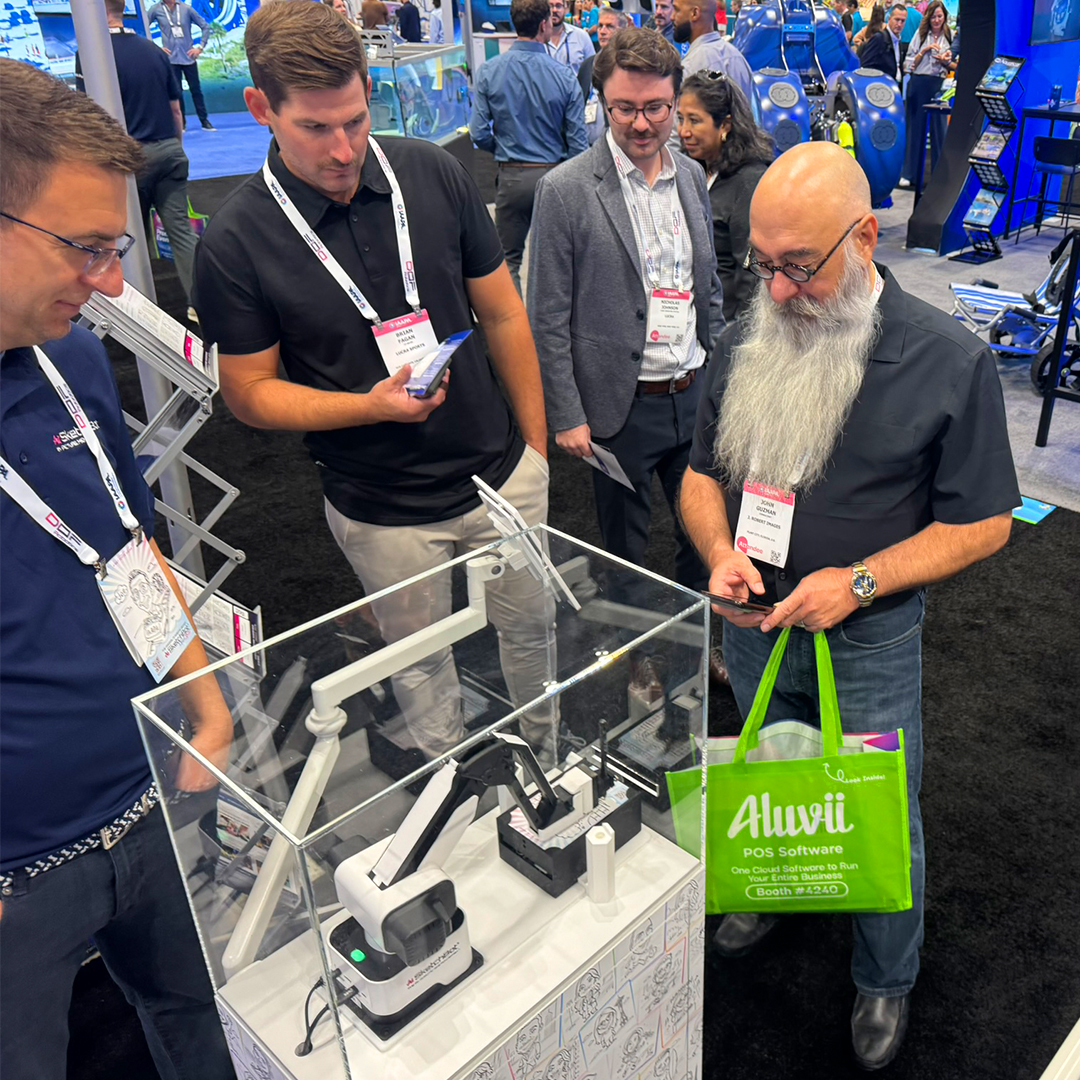 A crowd of people watching the SketchBot in action