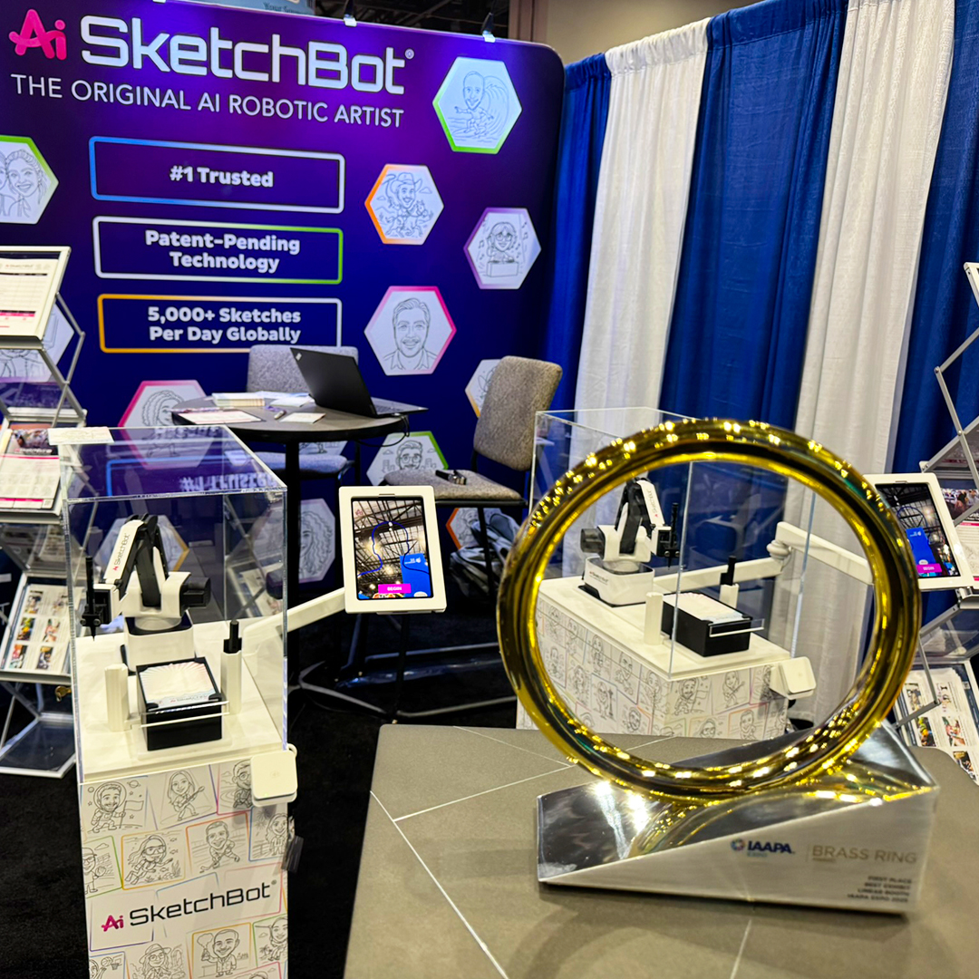 The IAAPA Brass Ring award in front of the SketchBot Kiosks
