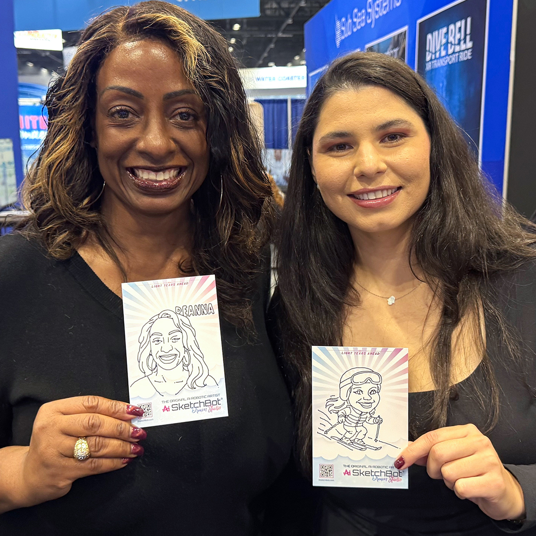 Two guests with their SketchBot drawings at the IAAPA booth