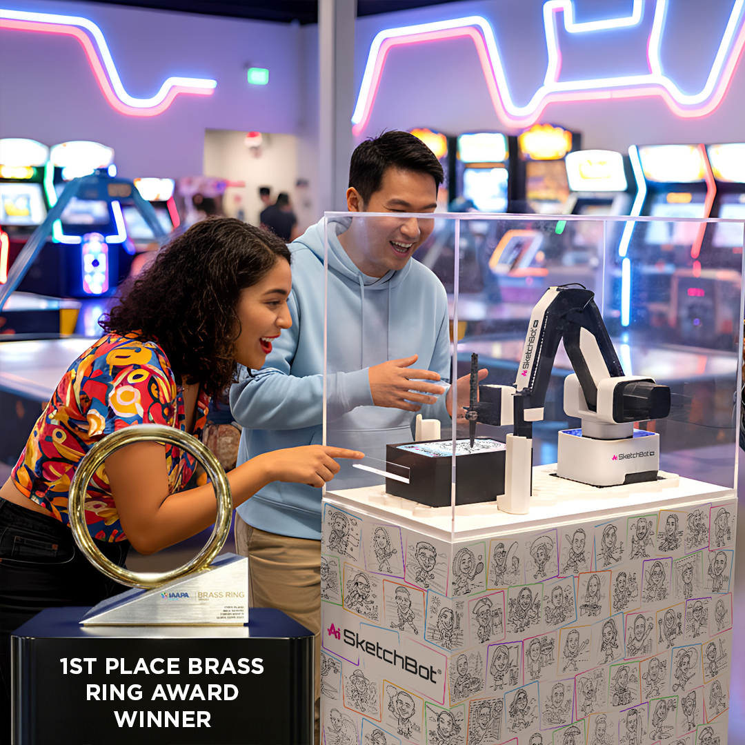 The SketchBot Kiosk in an arcade with The Brass Ring Award in front