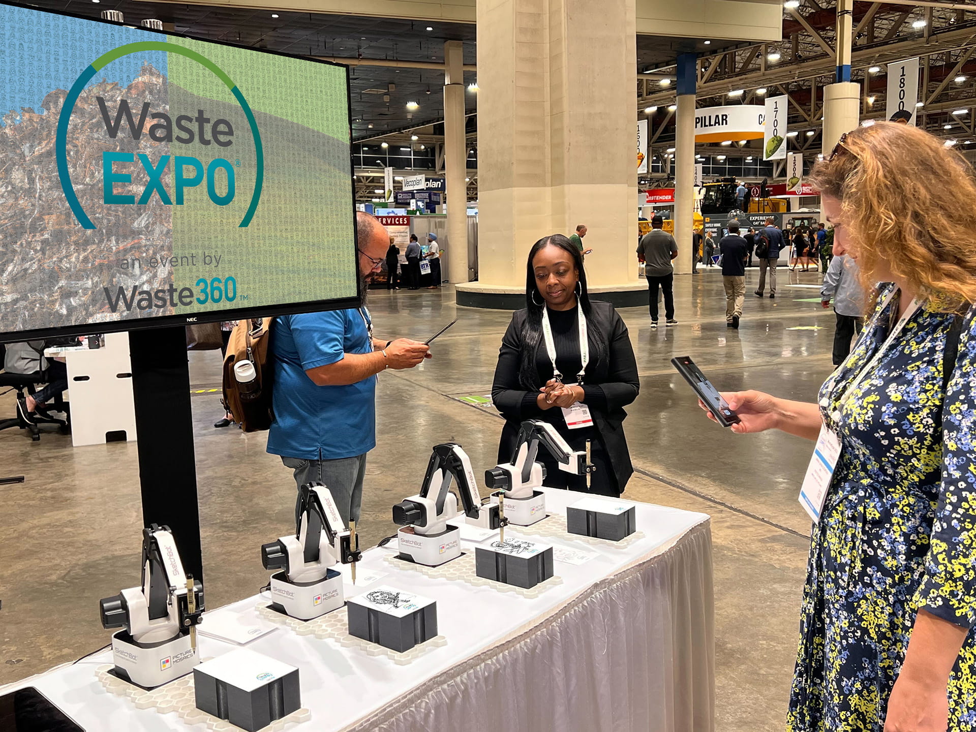 Event tech demonstrating SketchBot experience to guest as her portrait is drawn