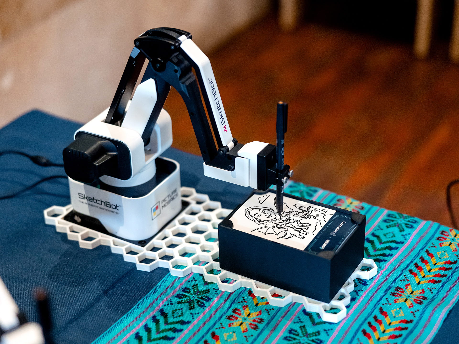SketchBot on a table drawing a custom portrait