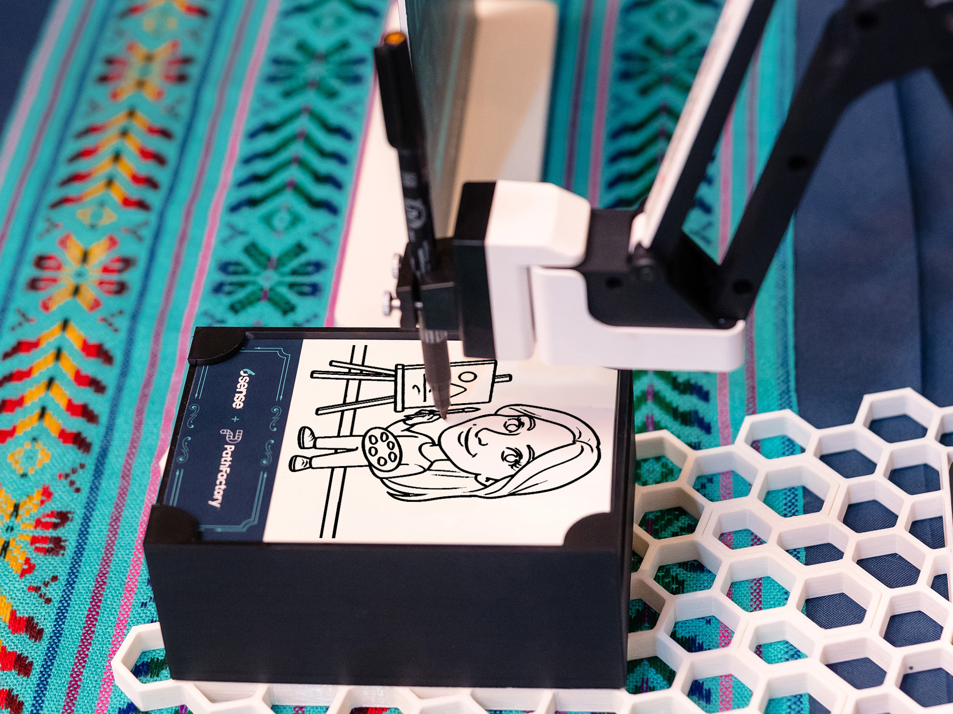 Close-up of a SketchBot drawing a guest's portrait on custom branded paper