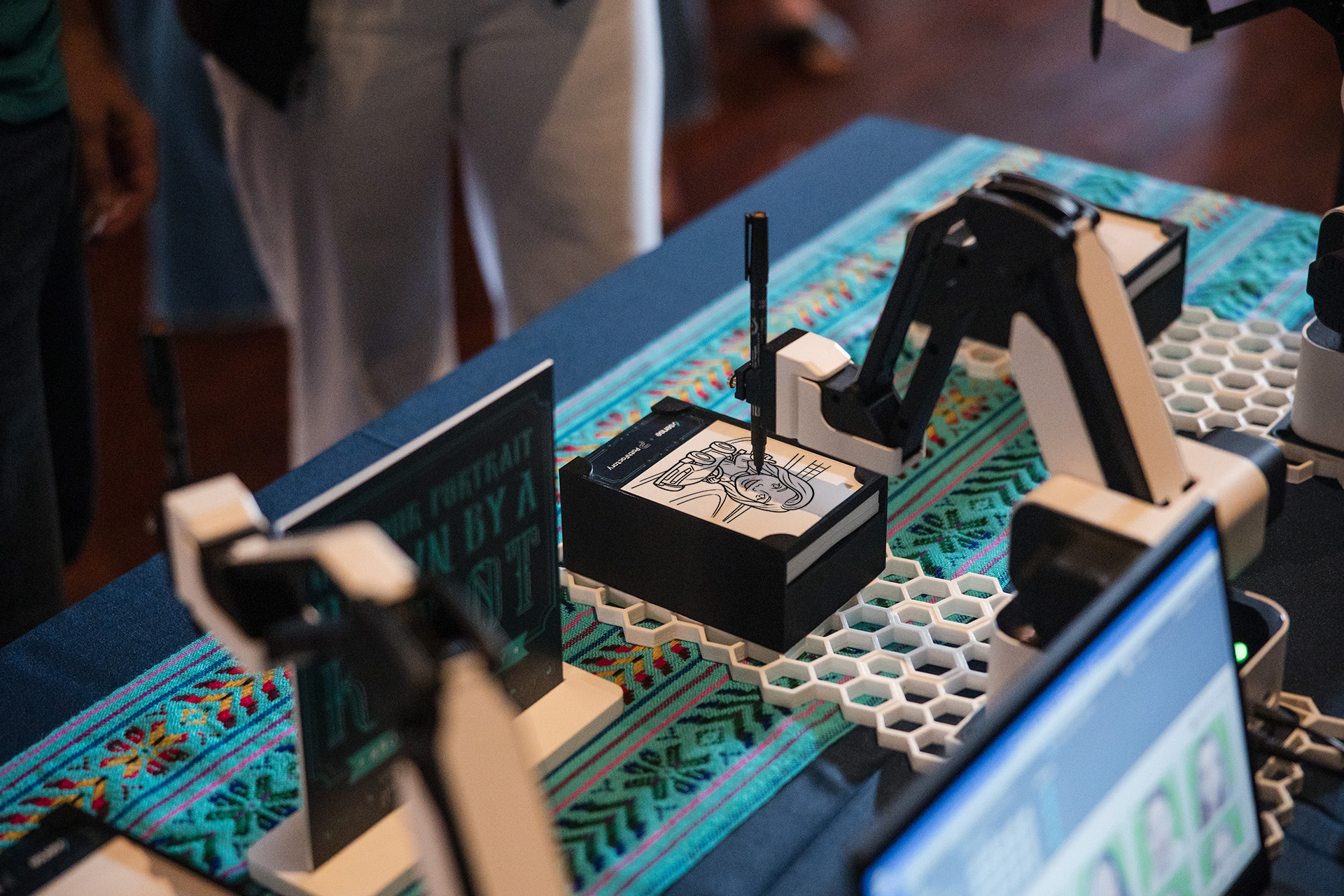 SketchBot drawing a man's portrait on branded 4x6 paper