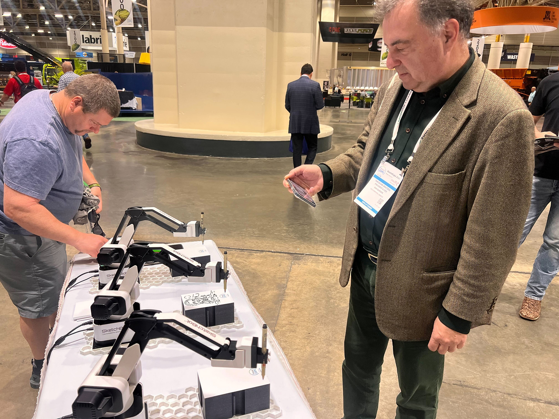 Guest recording SketchBot in action while it sketches his portrait at event