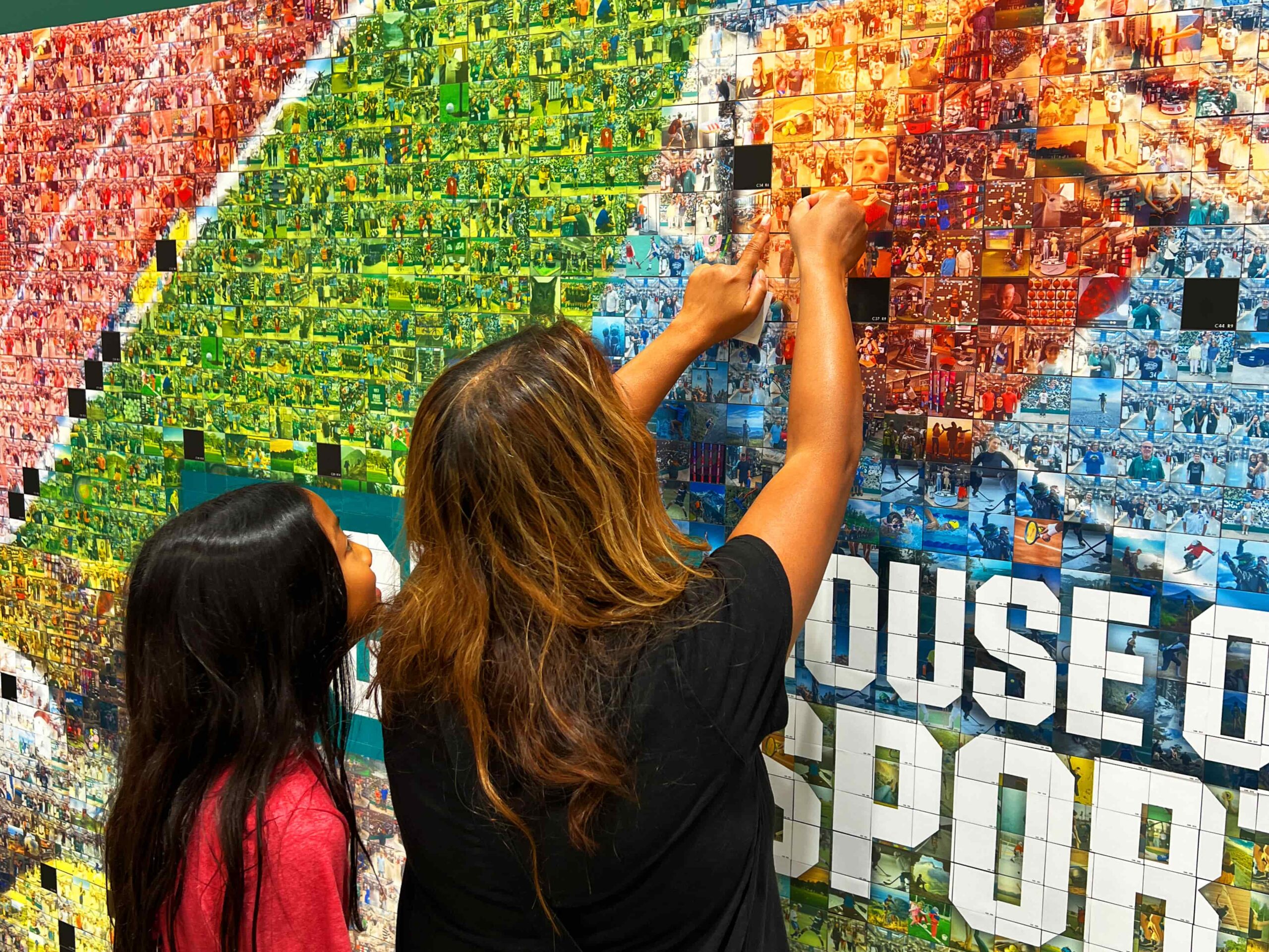 Guest placing their photo into the mosaic in order to complete it