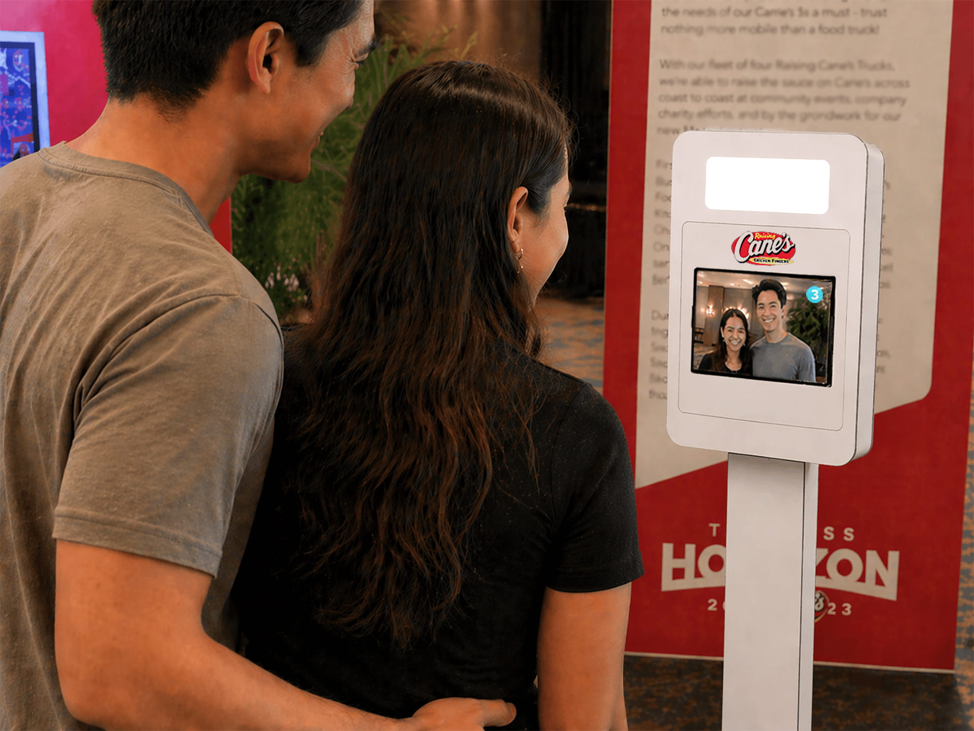 Two people standing in front of an iPad taking a picture