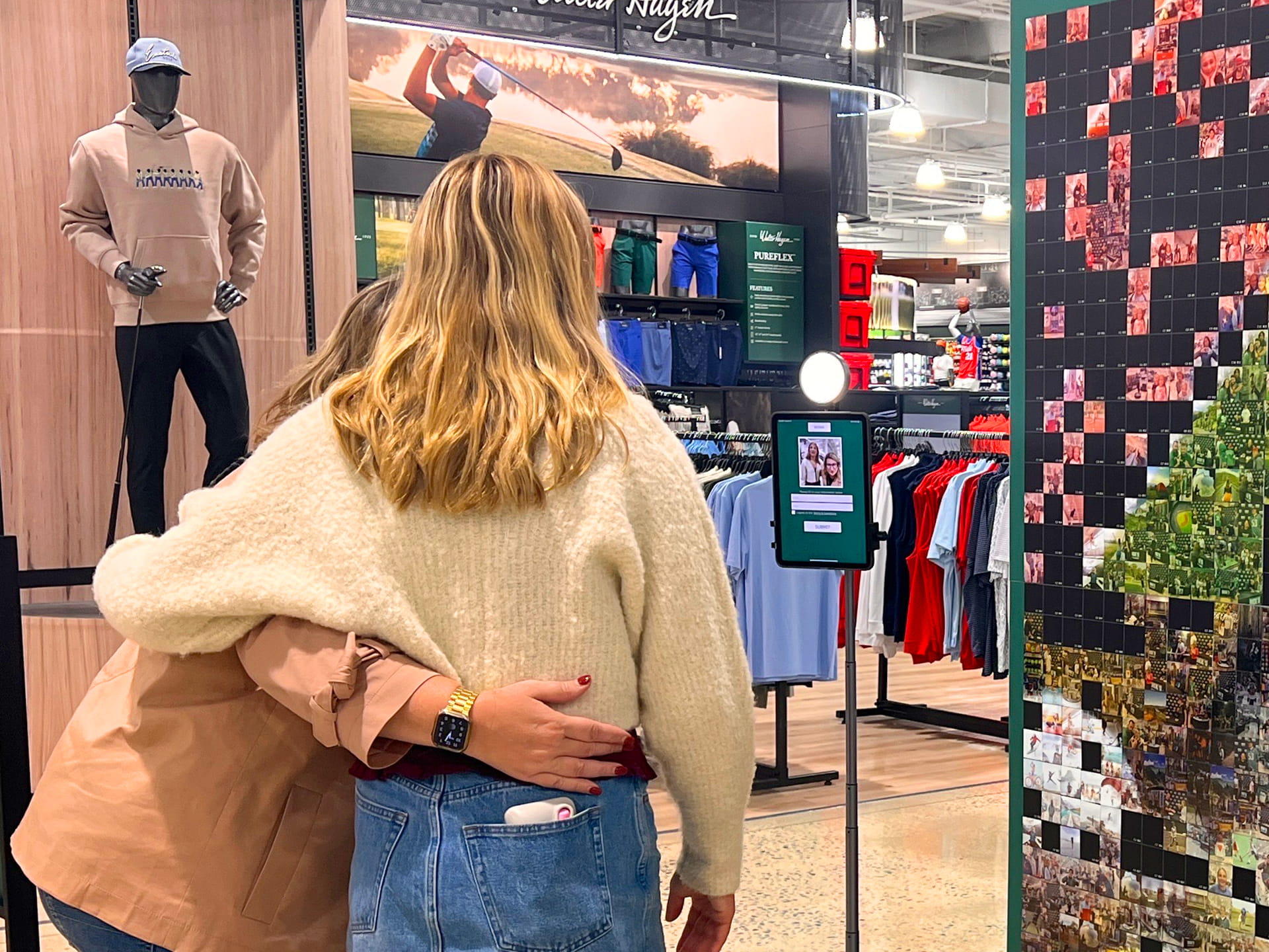 2 girls taking a photo on an iPad kiosk
