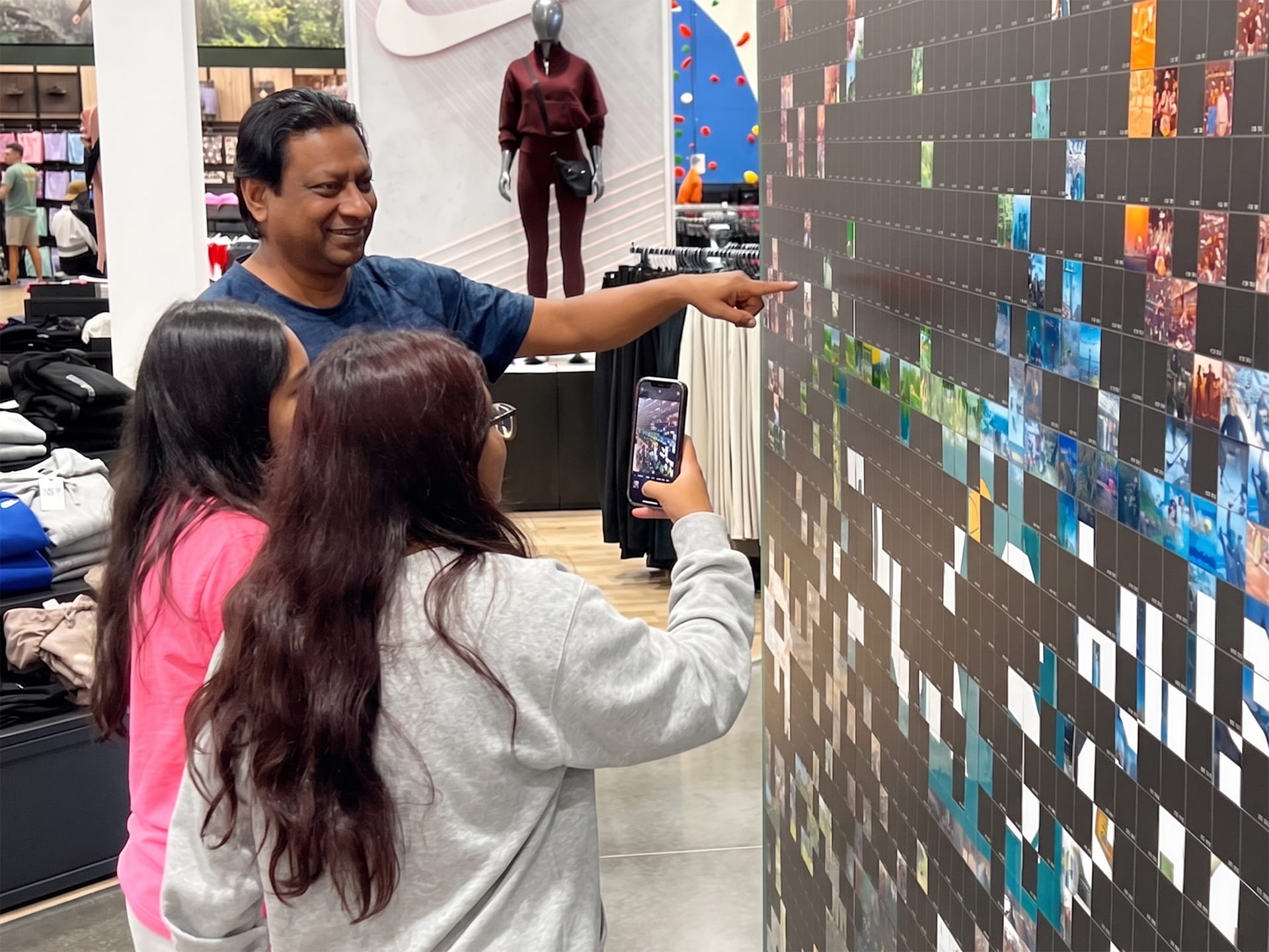 Guest taking a photo of the tile they placed on the mosaic wall