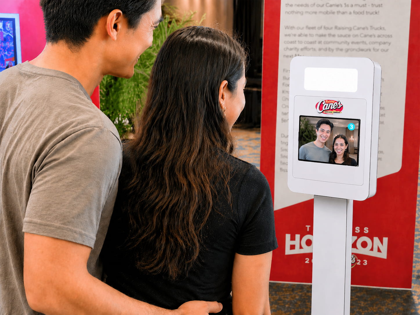 Two people standing in front of an iPad taking a picture