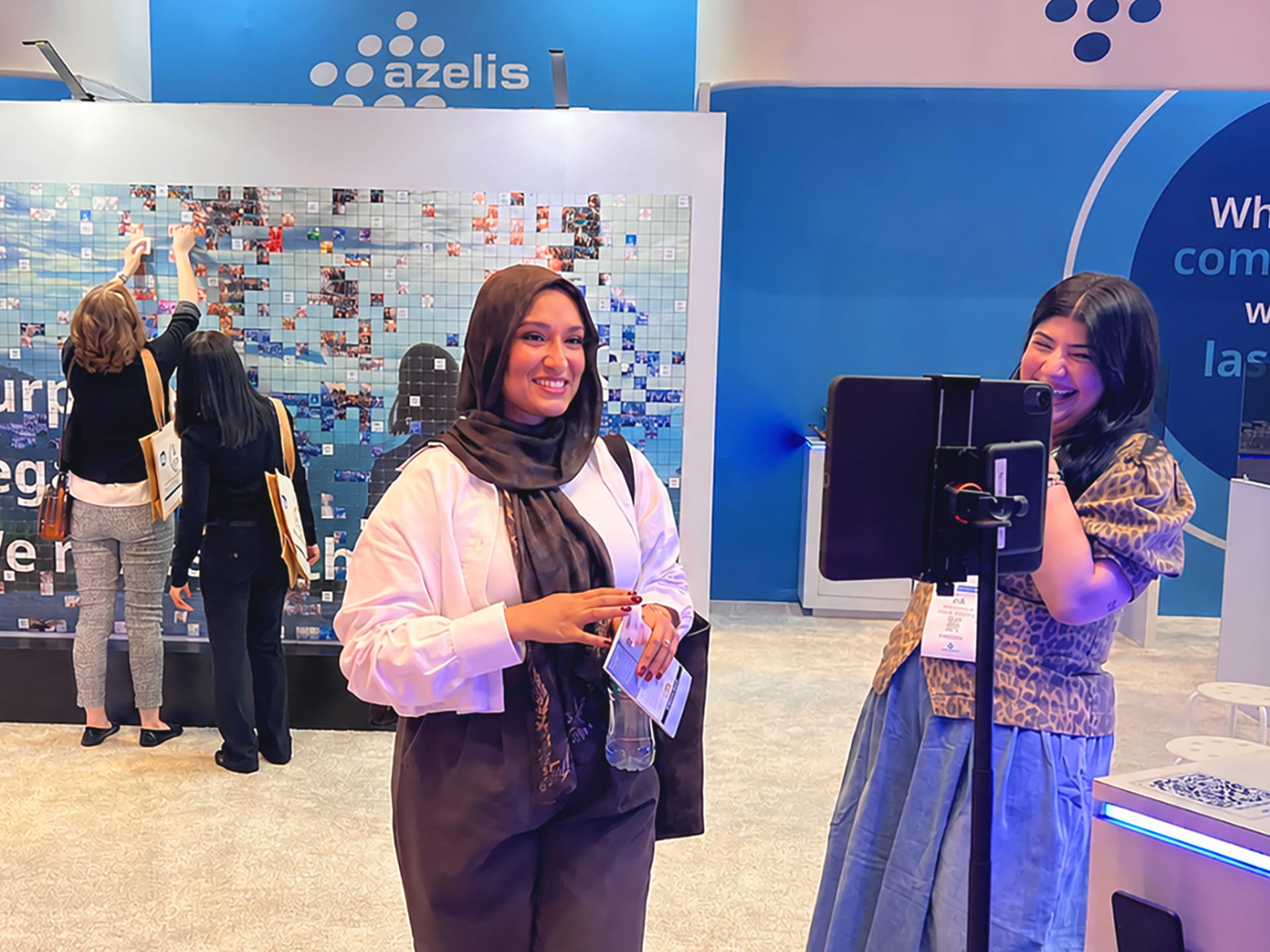 A participant taking their photo at an ipad kiosk