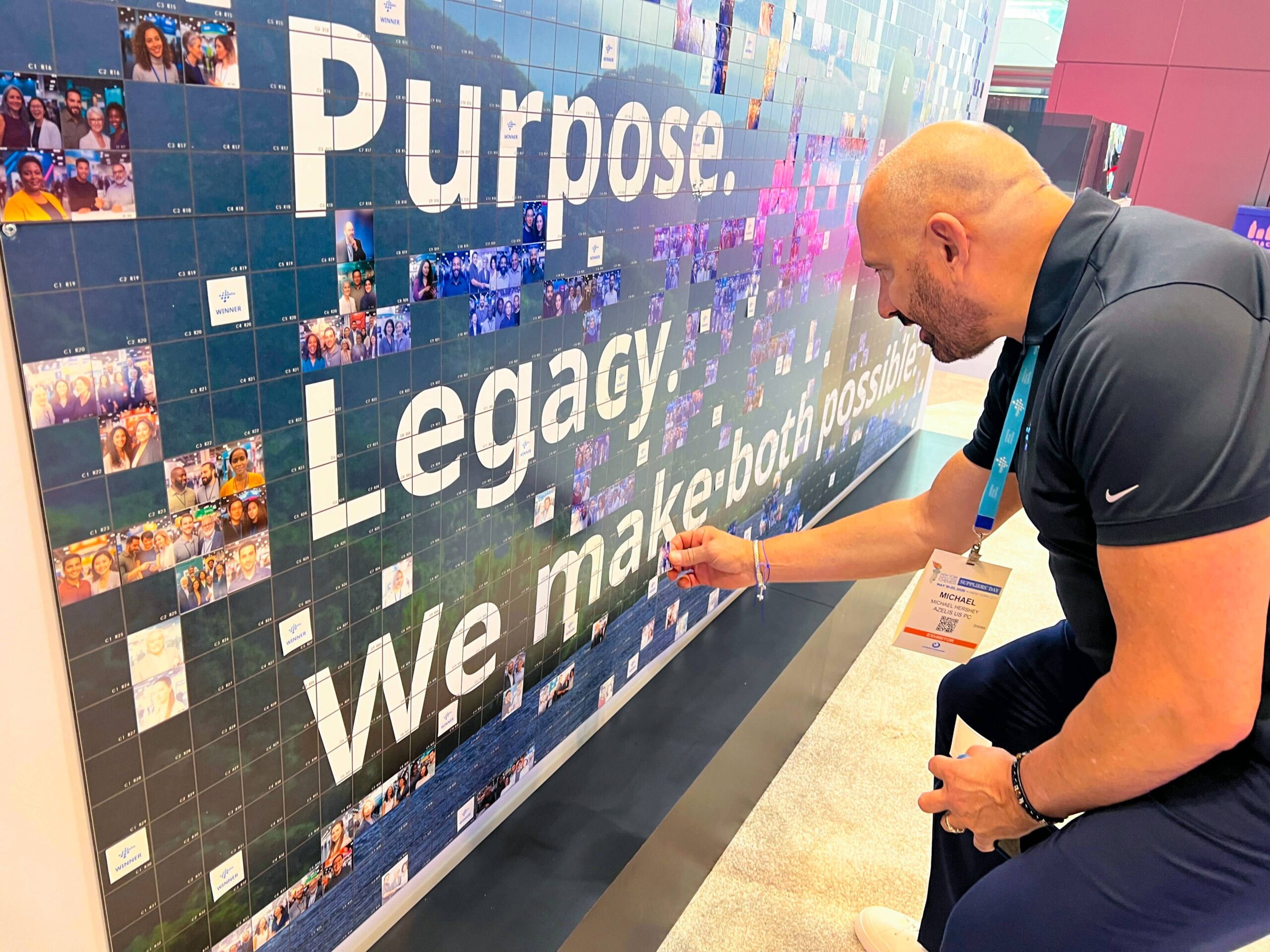 A guest placing their photo on the photo mosaic wall