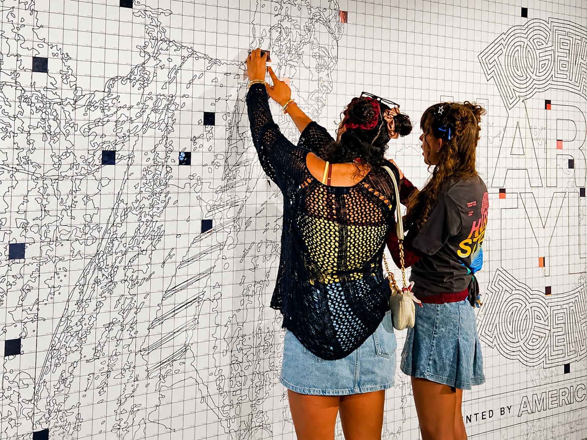 Two girls adding thier photos to the mosaic