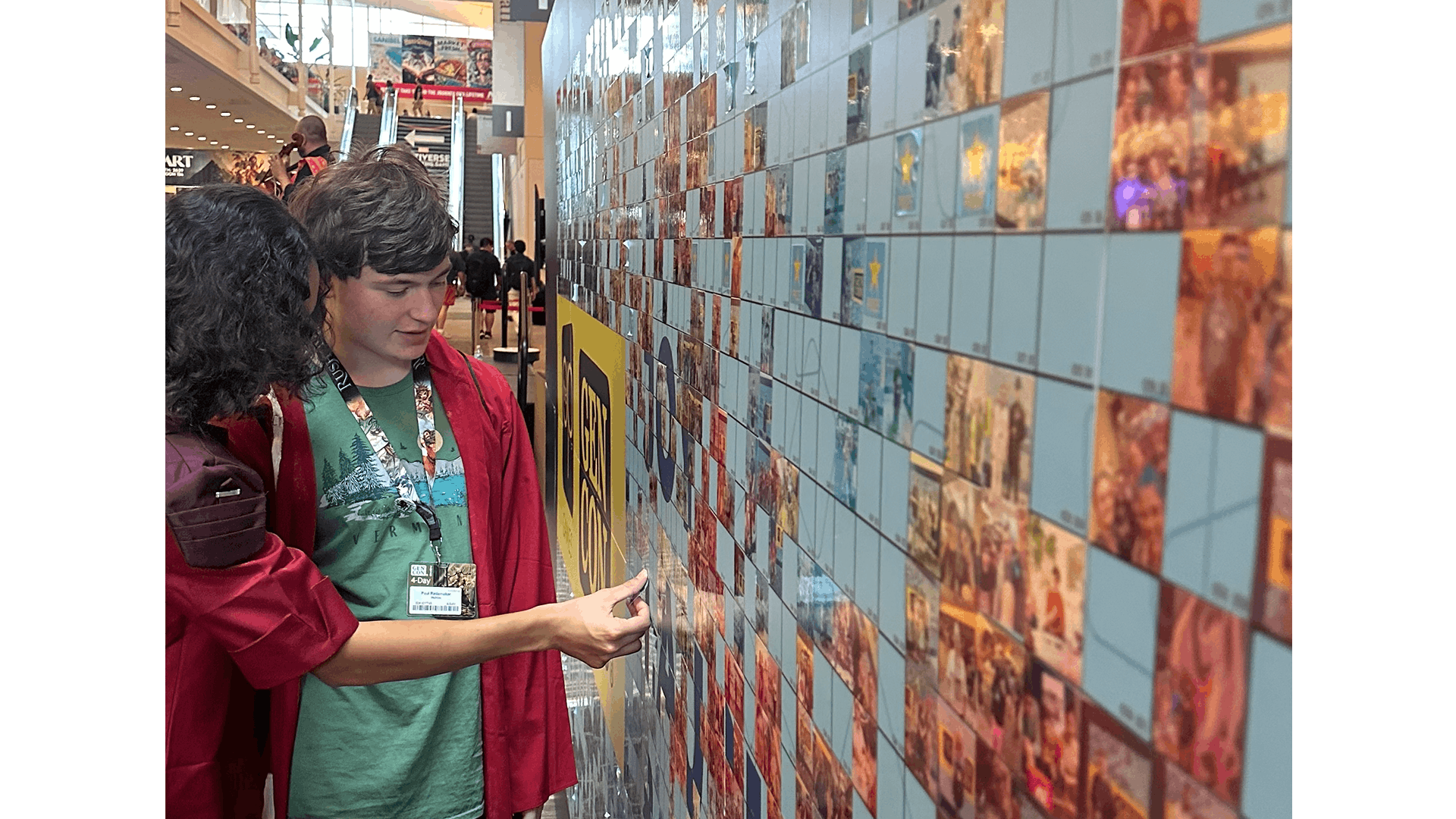 Two attendees placing their image on the photo mosaic wall