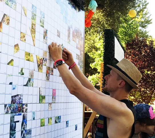 Guest placing a photo cell on a mosaic wall.