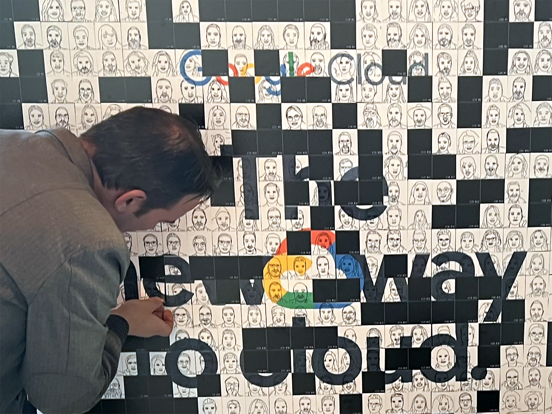 Ein Gast fügt sein Porträt zur SketchBot-Mosaikwand hinzu