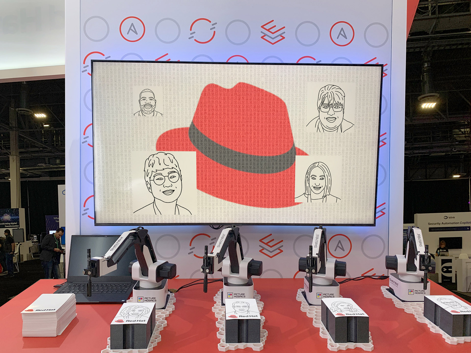 Mehrere Skizzierroboter, die personalisierte Mitbringsel zeichnen, wobei ein digitales SketchBot-Mosaik live auf einem Monitor angezeigt wird